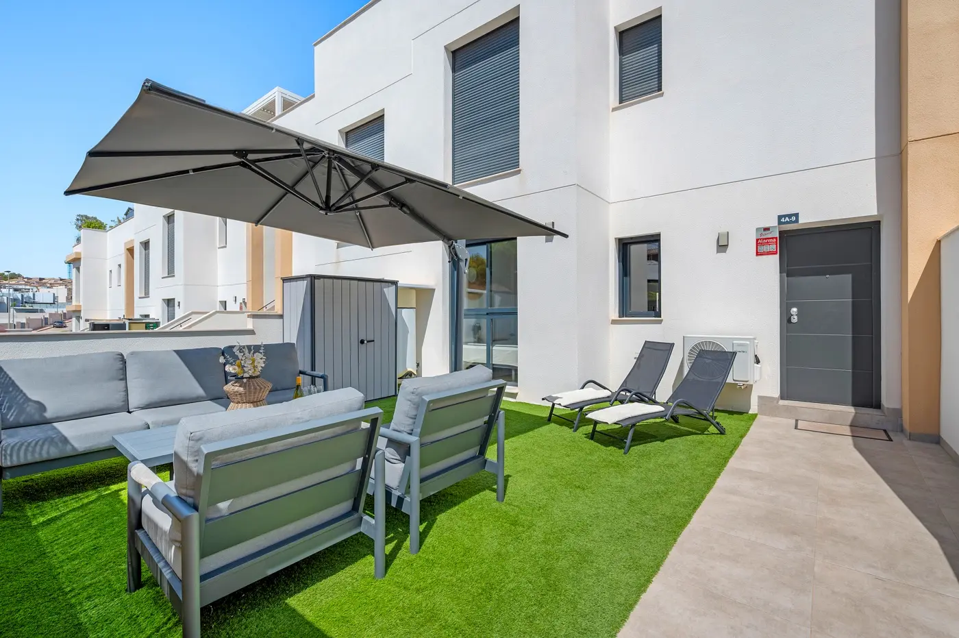 Private front garden with lounge set, sun loungers and modern façade