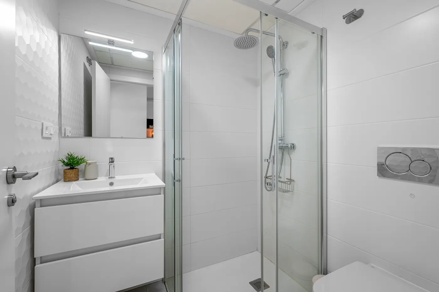 White shower room with glass enclosure and modern vanity