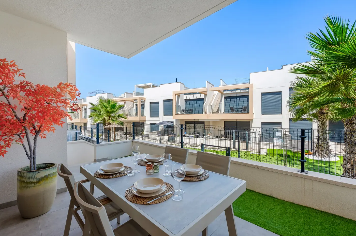 Terrace dining table with palm trees and residential view